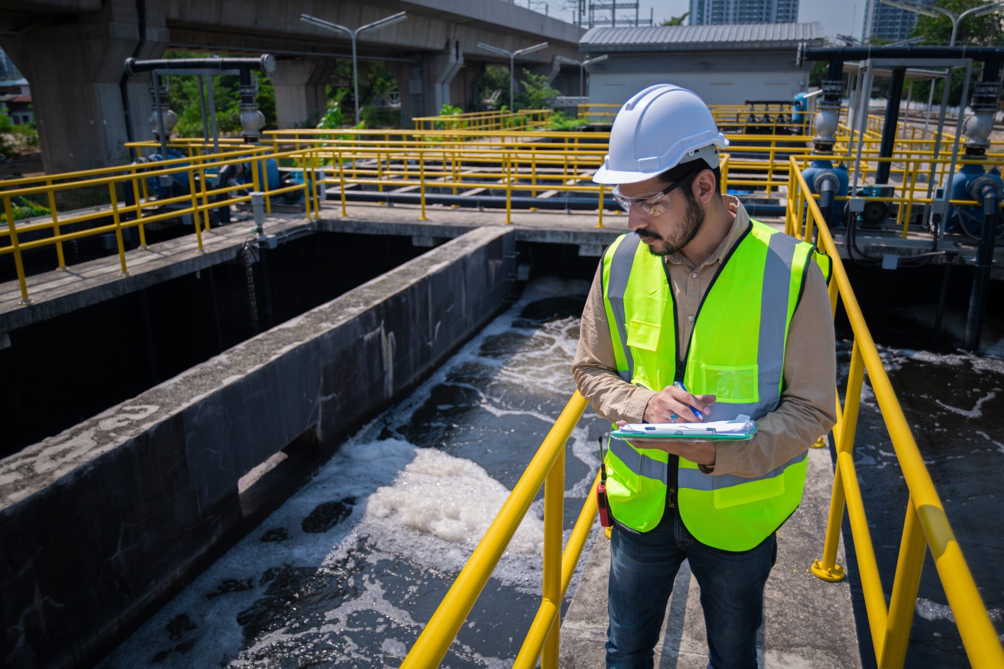 Worker inspecting industrial water treatment facility